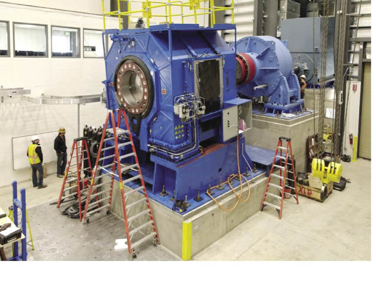 Progress on the 5-MW dyno is as recent as January. The large blue unit is the NTL. To its right is the dynamometer gearbox and behind that, the drive motor. The units mounted on a plane fixed at 5° to account for the nominal inclination of wind turbine drive lines.