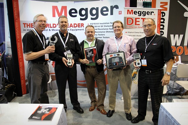 Megger staff members hold, from left to right, the following products: Clamp-on ground resistance tester, cable fault detector, the 2014 distributor catalog, 10-kV insulation tester, and the MOM2 micro-ohmmeter.
