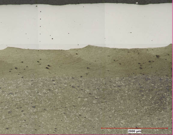 The cross section of a repaired surface shows laser clad stainless steel on a medium alloy steel substrate. Caterpillar has seven cells running, repairing mostly axel shafts, hydraulic rods, and other smaller components.