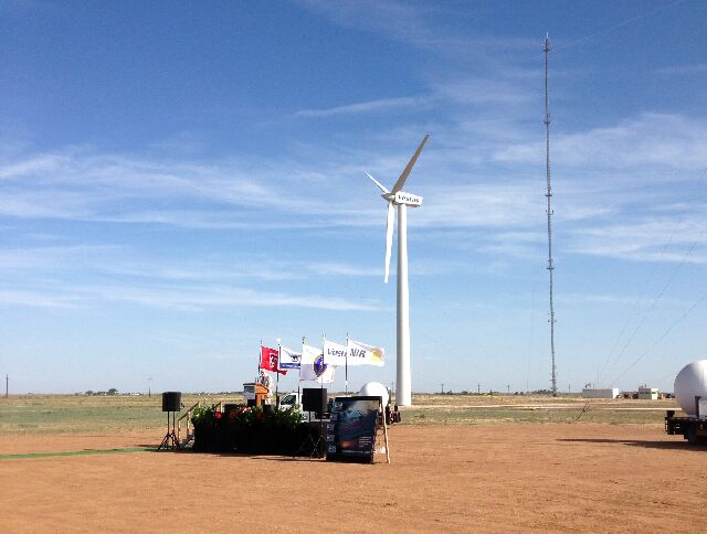 A retrofitted wind turbine serves as backdrop for the commissioning event where Kent Hance, Chancellor of the Texas Tech University System spoke to the group. The turbines contain ABB wind converters and Baldor induction generators. The tower in the background measures wind velocity, while the white Doppler Radar domes further serve to study how wind conditions affect the turbine performance: