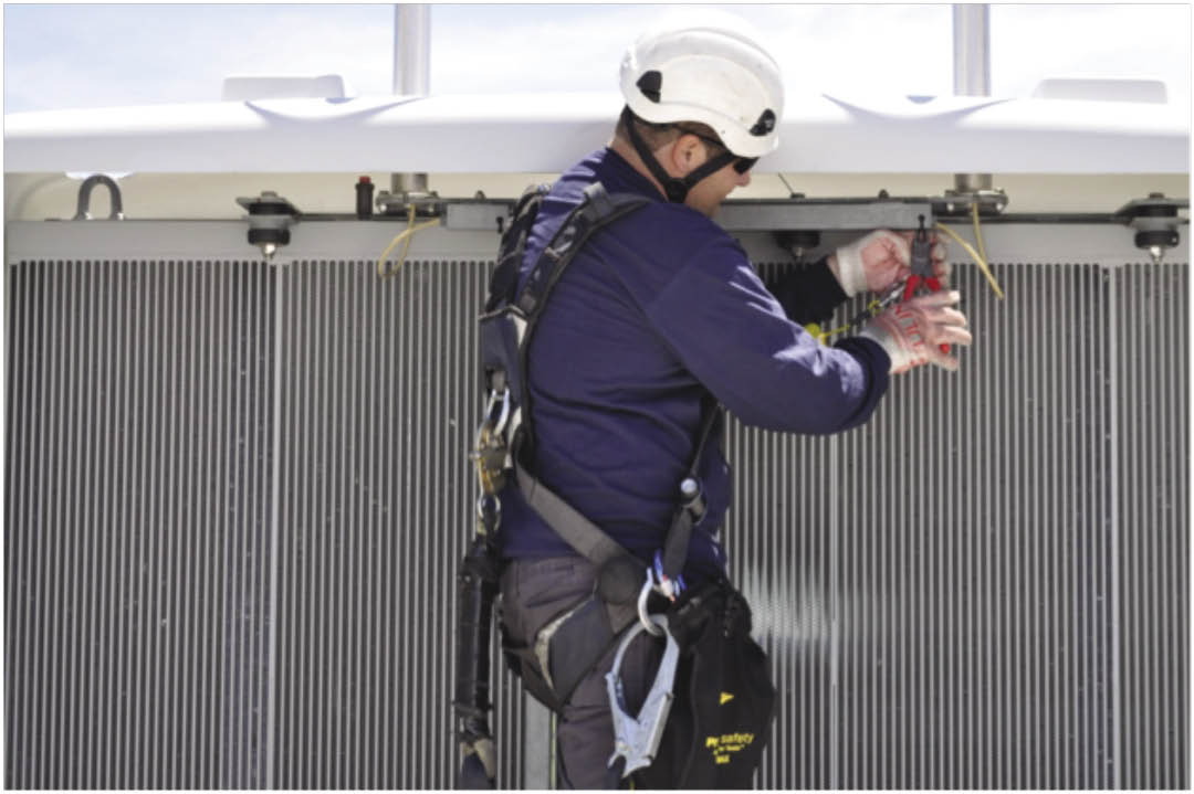 A wind technician uses a tethered cutting plier with an engineered attachment point located away from the gripping surfaces.