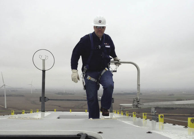 A common part of a wind technician's job is walking atop nacelles. Here, a technician uses a Wind TRAM. The safety device attaches to the worker’s waist, helping to prevent falls.
