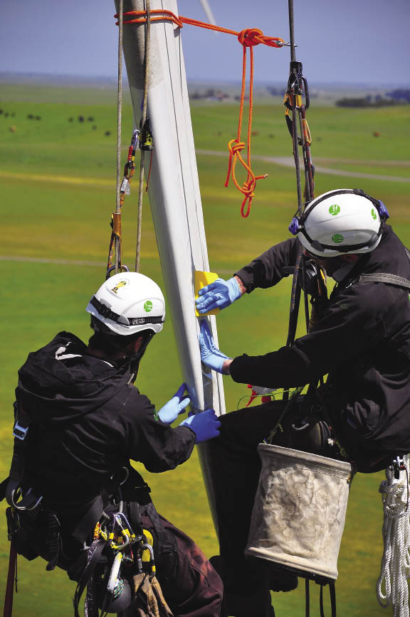 Wind turbine technicians at Rope Partners apply a 3M Wind Protection Tape to a blade’s lead edge. Photo: Rope Partners