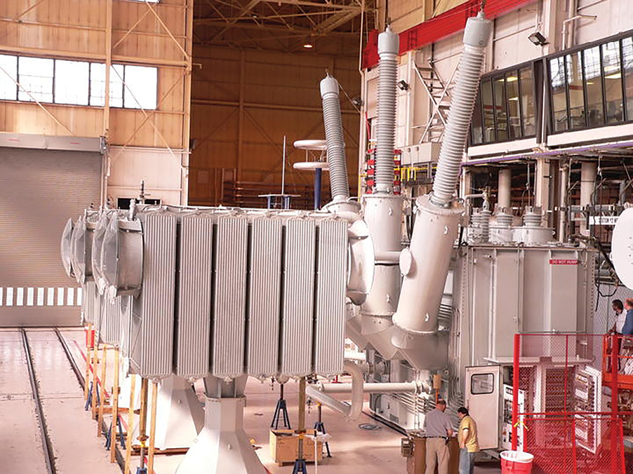 The large transformer is in its assembly phase at the ABB facilities in St.Louis. Bushings are the three large upward pointing connections, one for each phase. Although these transformers are not headed to wind farms, they are similar in size and function to such units.