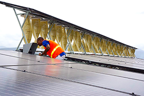 An installer working on a portion of the 80 kW hybrid rooftop installation.