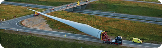 To understand some of the challenges of transporting a long structure, count the lead and trailing vehicles. A modular blade such as the one proposed will avoid tight turns as well as other difficulties.