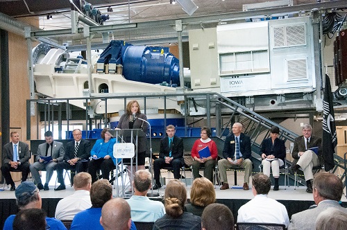 College President Valerie Newhouse addresses visitors during the open house of Sustainable Energy Resources & Technology facility. Behind her is a Gamesa G87 drivetrain on which wind technicians will train. Director of Wind Energy & Turbine Technology Dan Lutat sits to the far left.