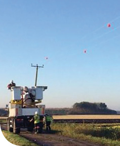 The apparently floating  red dots are red sphere attached to power lines that warn migrating birds away.