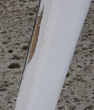 On a computer, a 25 megapixel image of this damage allows zooming in to see that the fiberglass shell has been exposed. 