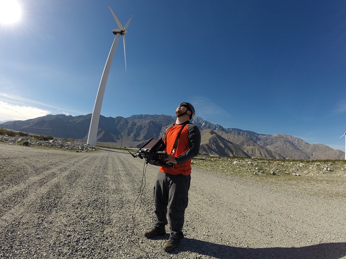 An AAIR technician keeps an eye on a drone during a test inspection. The control panel includes a 7-in. screen so the pilot sees what the camera sees.