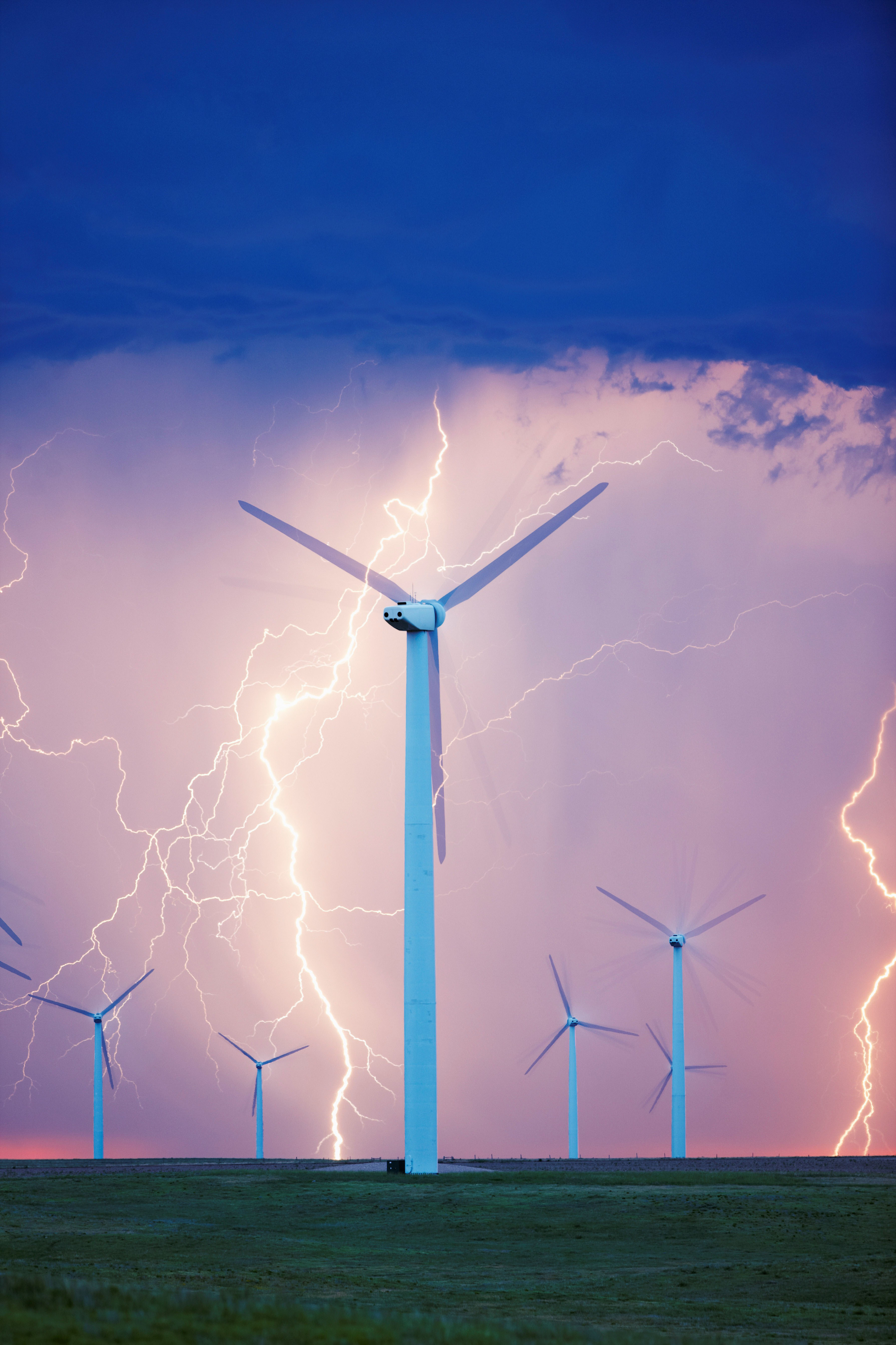 D0DFP3 Severe thunderstorm unleashes lightning behind a wind turbine at a wind farm in Colorado.