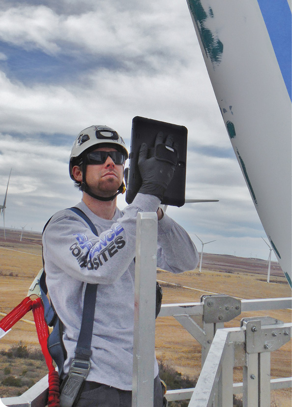 A wind technician takes pictures of blade damage with a Sequoia CMMS Tablet Application. Pictures and comments will be in a report in the owners hands soon after the technician gets down tower. Photo: Performance Composites
