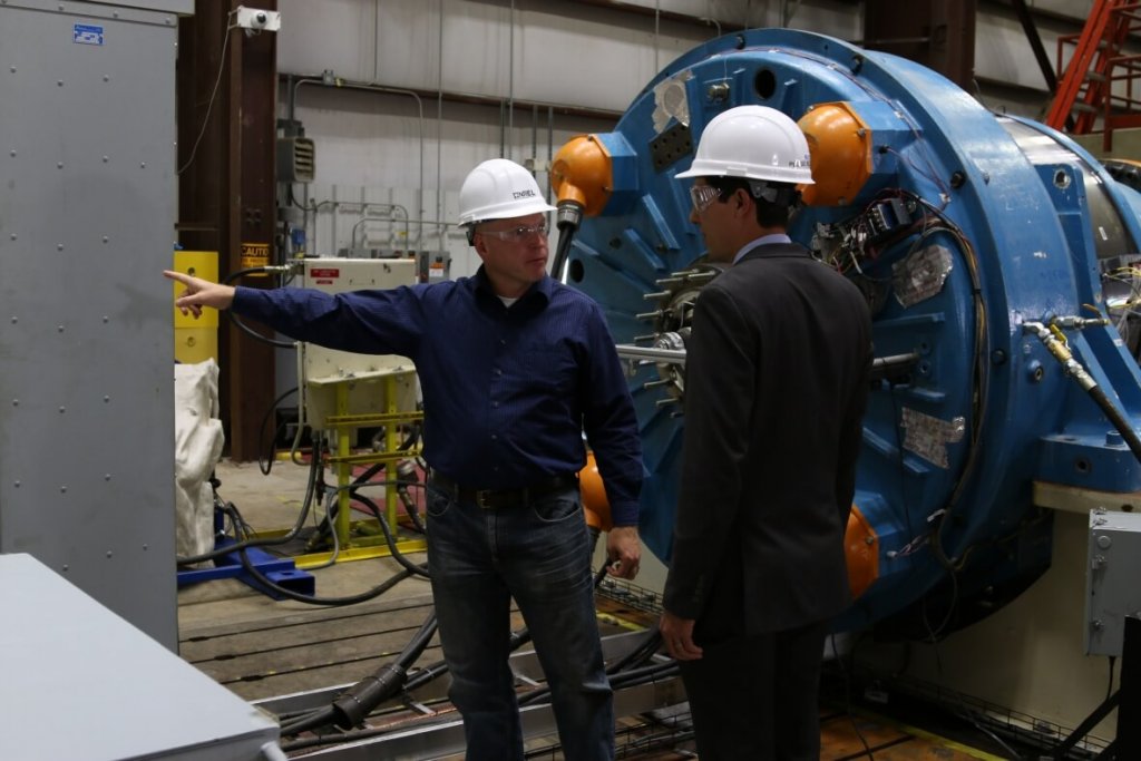 NREL researchers are completing testing of a next-generation drivetrain, shown here undergoing rigorous tests at the National Wind Technology Center’s 2.5-megawatt dynamometer. NREL’s testing validates the technology prior to commercialization. Shown here are NREL senior engineer and project lead Jonathan Keller (left) and DOE technology manager Nick Johnson. Photo by Malone Media