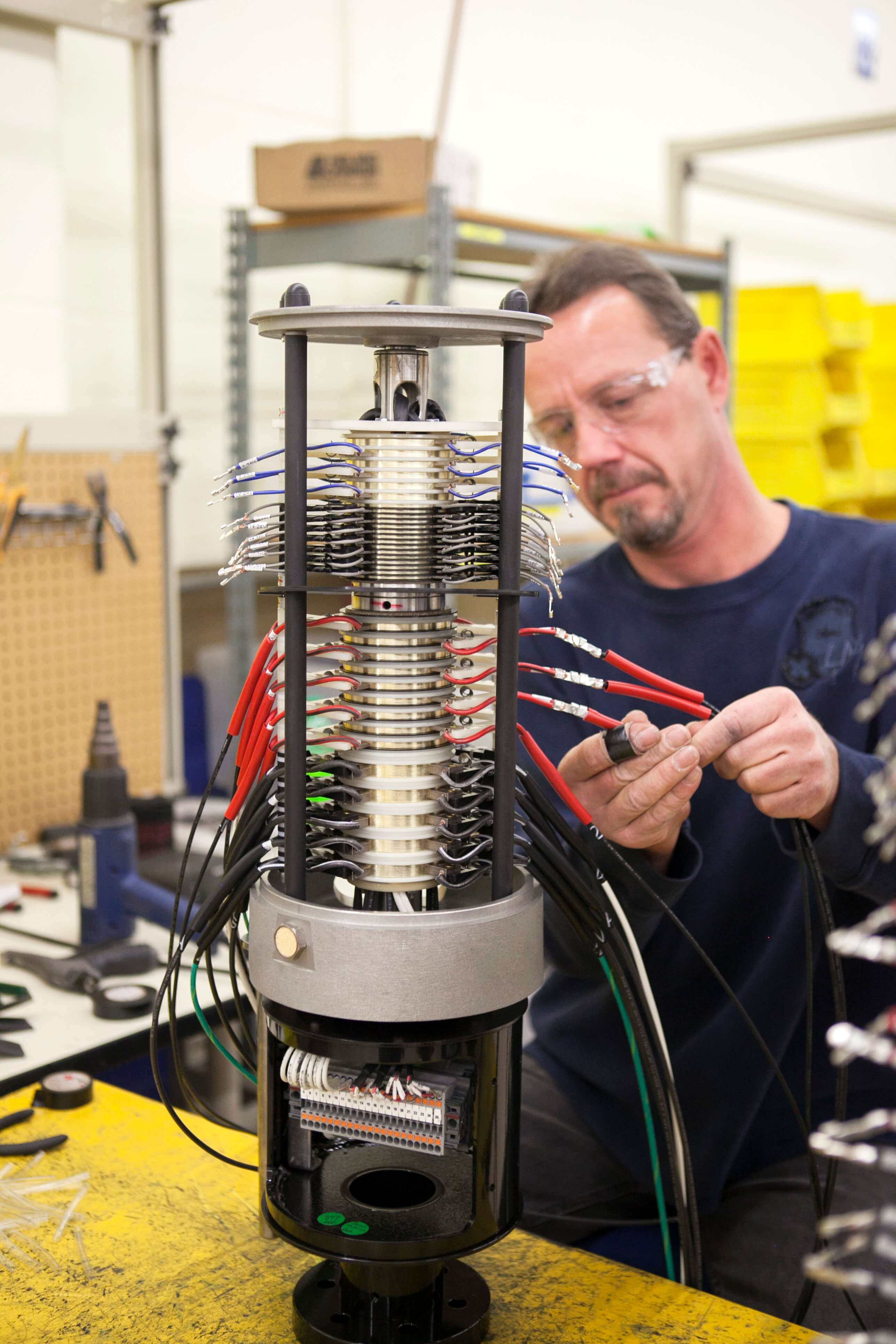 A United Equipment Accessories technician assembles brush harnesses on a slip ring.