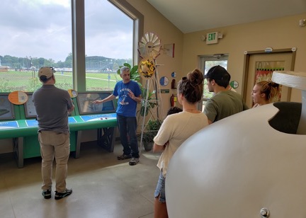 Cleveland Power of Wind Action Team member Tom Schock explains the instrument panel to visitors of the Sustainability Center